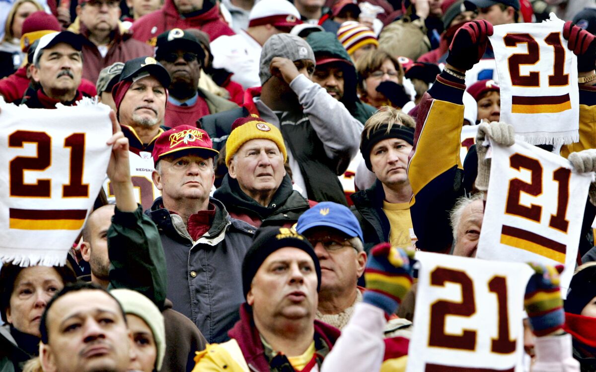 FILE - In this Dec. 2, 2007, file photo, solemn football fans hold up towels with No. 21 in memory of slain Washington Redskins safety Sean Taylor during a ceremony before an NFL football game against the Buffalo Bills at FedExField in Landover, Md. The Washington Football Team plans to retire late safety Sean Taylor's number before its upcoming game against Kansas City. (AP Photo/J. Scott Applewhite, File)