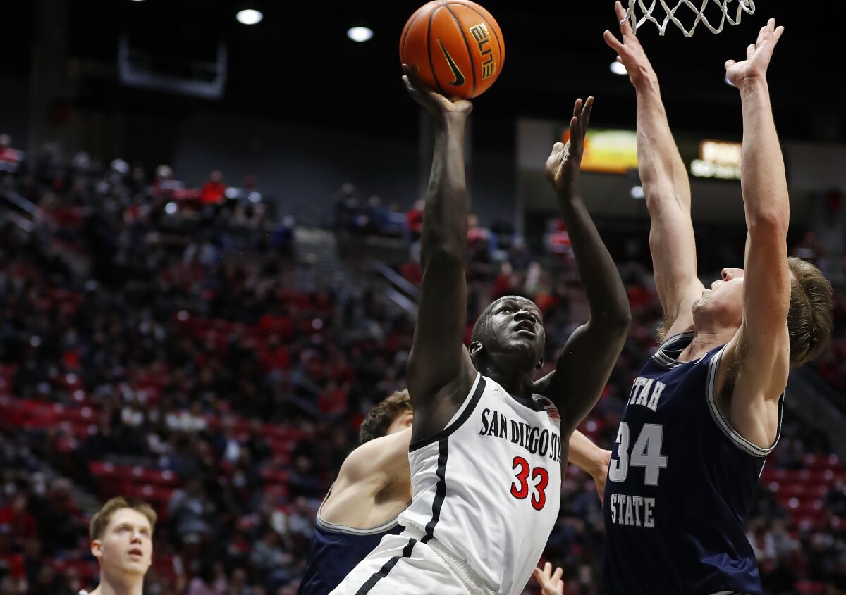 SDSU's Aguek Arop goes up for a shot against Utah State's Justin Bean on Tuesday at Viejas Arena.
