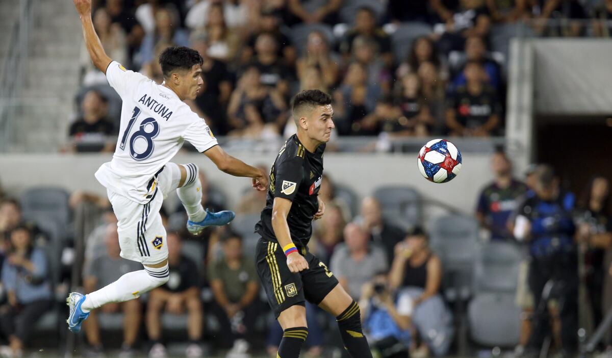 Galaxy midfielder Uriel Antuna, left, and LAFC midfielder Eduard Atuesta battle for the ball during the first half on Aug. 25.