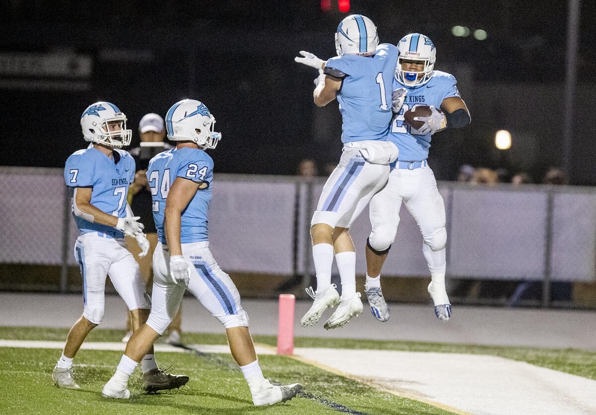 Corona del Mar's Max Lane (1) leaps up to meet Evan Sanders (22) after he scored a touchdown in the second half.