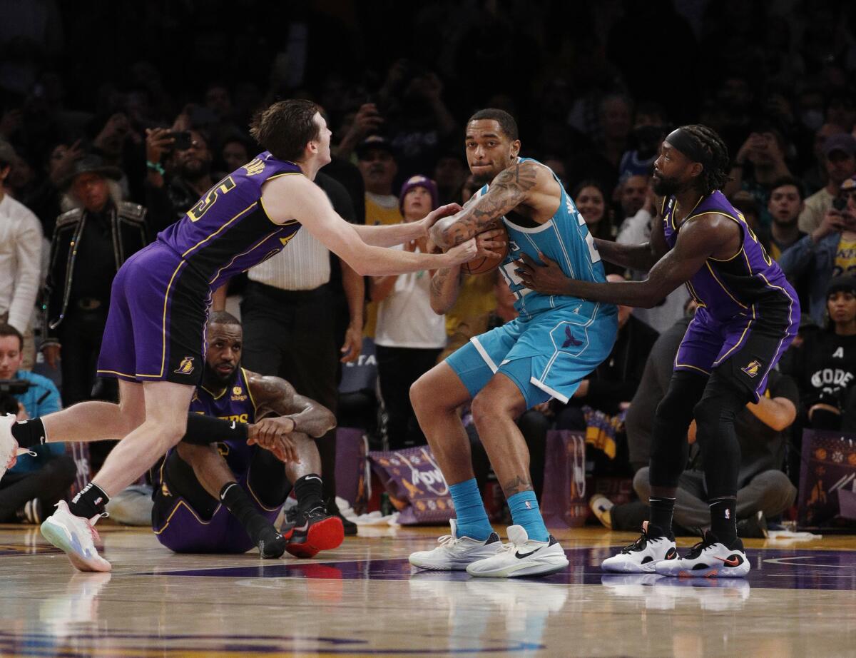 Charlotte Hornets forward P.J. Washington grabs a loose ball after Lakers star LeBron James lost his right shoe.