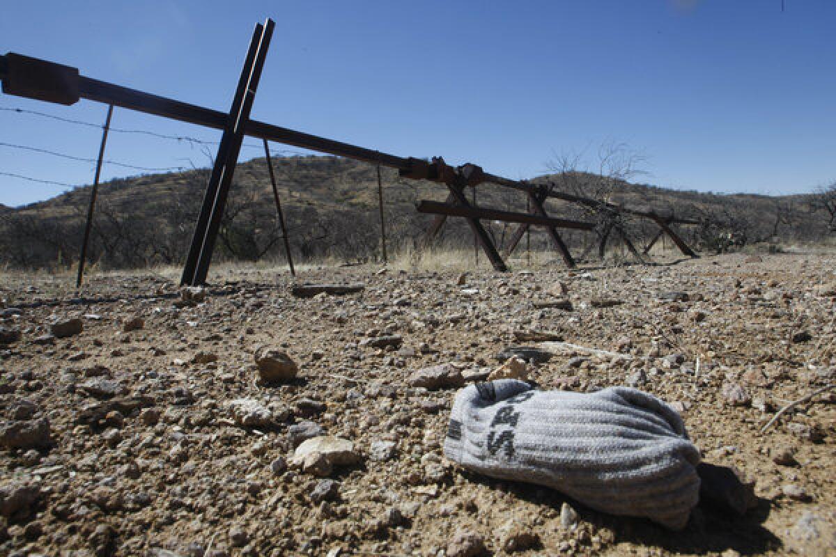 A pair of socks dropped by a migrant lies on the Arizona side of the U.S./Mexico border fence. Border Patrol agents patrolling the southern Arizona desert rescued 177 people in the last 30 days as temperatures soared to dangerous levels.