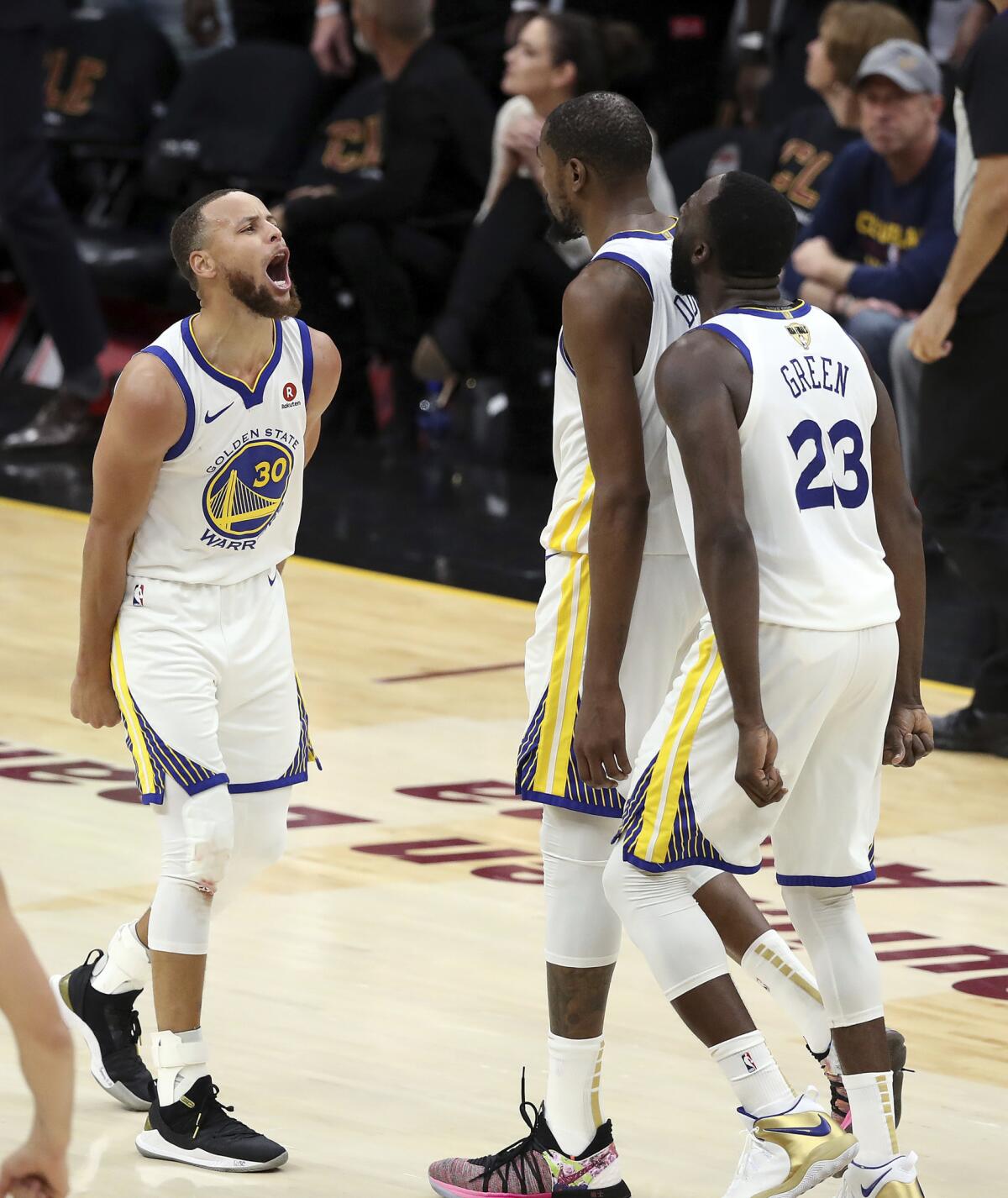 Kevin Durant, de los Warriors de Golden State, festeja con Stephen Curry (izquierda) y Draymond Green, durante el tercer partido de la serie final de la NBA ante los Cavaliers de Cleveland, el miércoles 6 de junio de 2018 (AP Foto/Carlos Osorio)