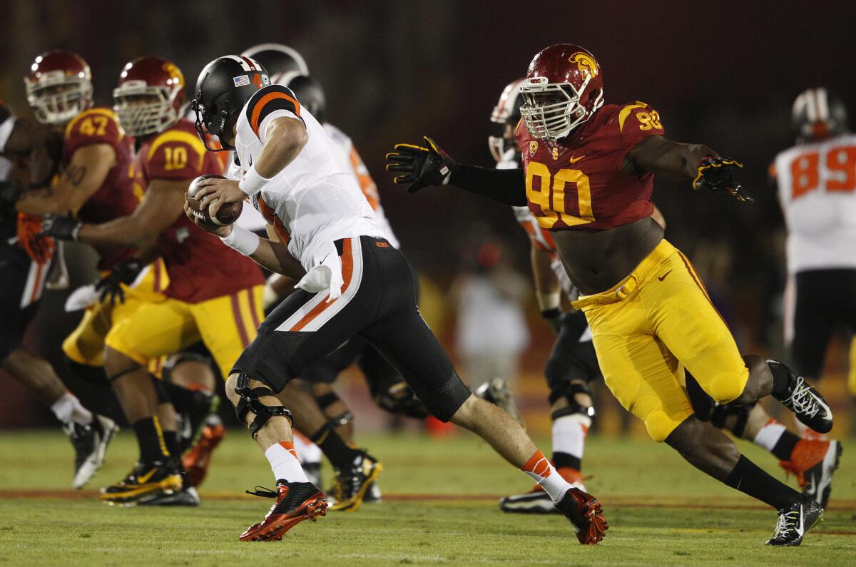 USC defensive tackle Claude Pelon (90) chases down Oregon State quarterback Sean Mannion in September.