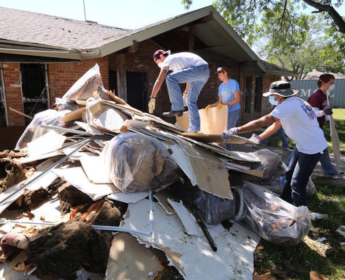 Students clean debris at a home in West, Texas, that was damaged in the fertilizer plant explosion that killed 14 people last month. Lawyers said Saturday the plant only had $1 million in liability coverage.