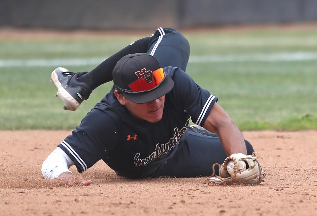 Tony Martinez of Huntington Beach makes a diving stop of a hard-hit ball to third base, getting the runner at first.