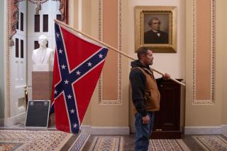 (FILES) A supporter of US President Donald Trump holds a Confederate flag outside the Senate Chamber during a protest after breaching the US Capitol in Washington, DC, January 6, 2021. - The demonstrators breeched security and entered the Capitol as Congress debated the 2020 presidential election Electoral Vote Certification. (Photo by SAUL LOEB / AFP) (Photo by SAUL LOEB/AFP via Getty Images)