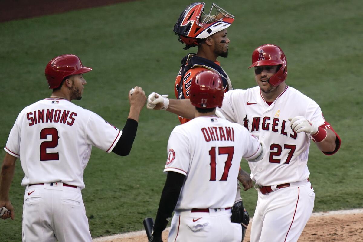 Angels' Mike Trout celebrates his two-run home run with Andrelton Simmons and Shohei Ohtani.