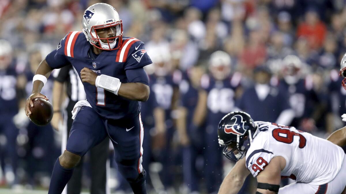 Patriots quarterback Jacoby Brissett scrambles away from Texans defensive end J.J. Watt during the second half Thursday.