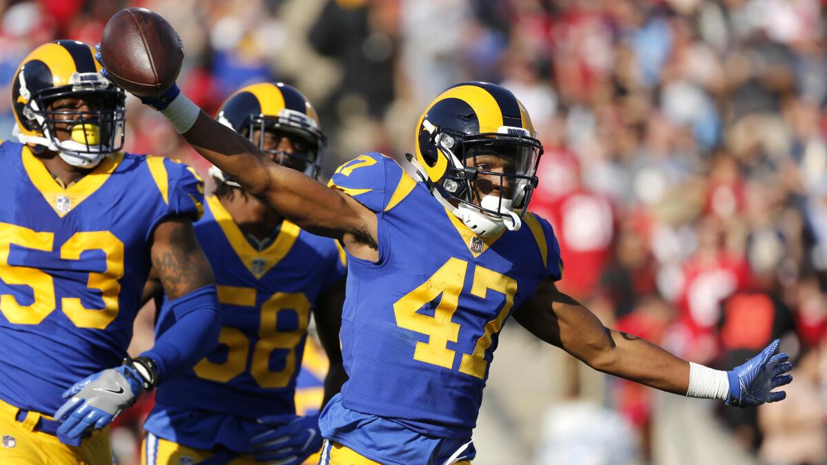 Rams cornerback Kevin Peterson (47) celebrates with teammates Carlos Thompson (53) and Cory Littleton (58) after intercepting a pass by 49ers quarterback Jimmy Garoppolo on Sunday at the Coliseum.