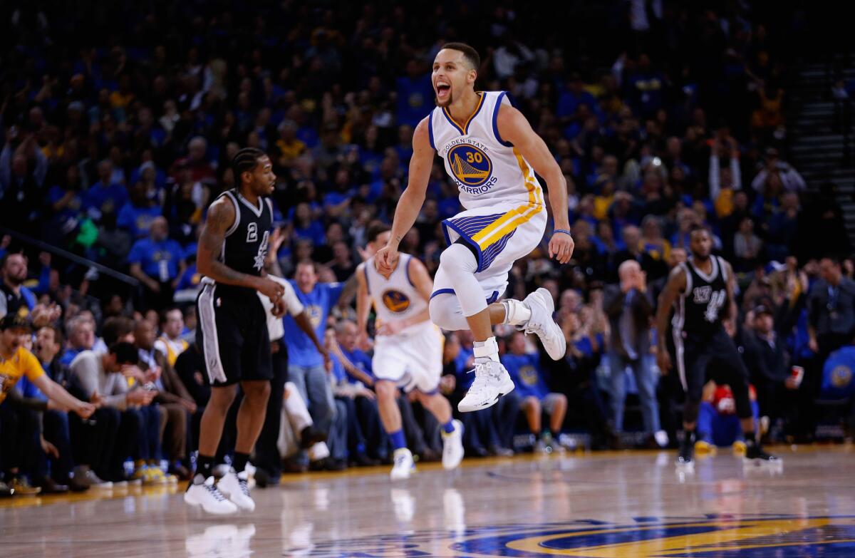 Warriors guard Stephen Curry skips through the air after he made a shot against the Spurs during the third quarter.
