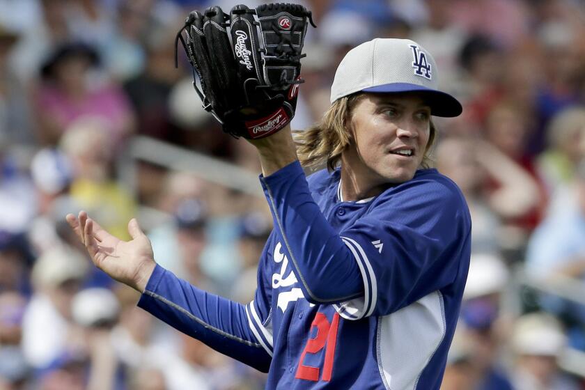 Zack Greinke reacts after a fly ball goes over his head during the second inning of the Dodgers' spring training loss Wednesday to the Chicago Cubs, 4-3.