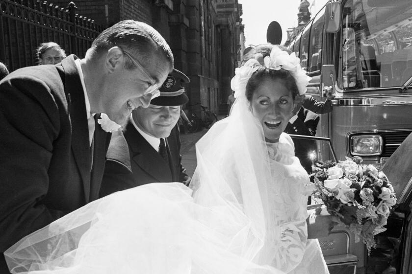 Dodgers president Peter O'Malley helps his bride, Annette Zacho, into a car following their wedding in 1971