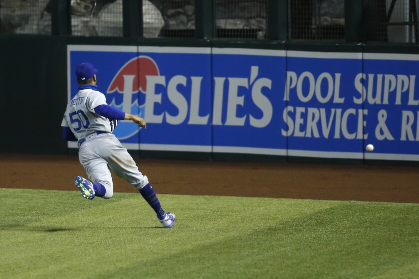 The Dodgers' Mookie Betts tries to chase down a three-run double hit by the Diamondbacks' Christian Walker on July 31, 2020.