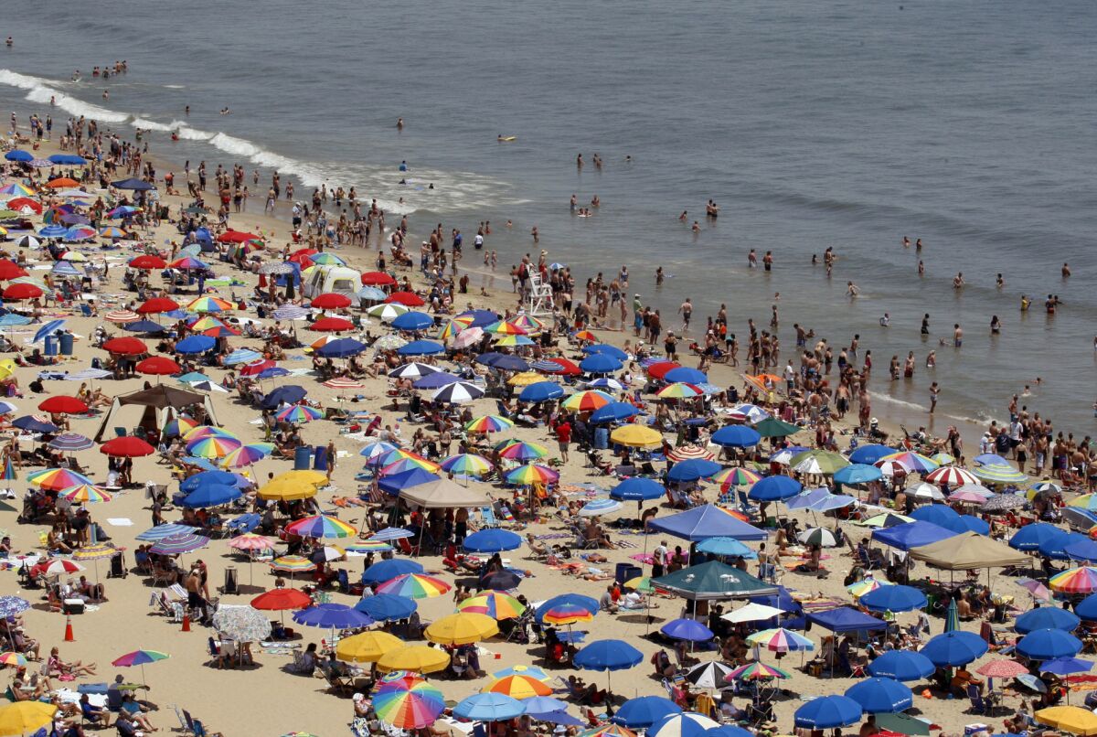 FILE- In this June 9, 2012, file photo, people crowd the beach in Ocean City, Md. A federal appeals court on Wednesday, Aug.4, 2021, affirmed a Ocean City's right to ban women from topless sunbathing. A three-judge panel of the 4th U.S. Circuit Court of Appeals in Richmond ruled unanimously that Ocean City's law, which allows men to be topless but not women, is constitutional. Ocean City passed its law in 2017 after one of the plaintiffs in the case, Chelsea Eline, contacted Ocean City police and asserted a right to go topless. (Amanda Rippen White/The News Journal via AP)