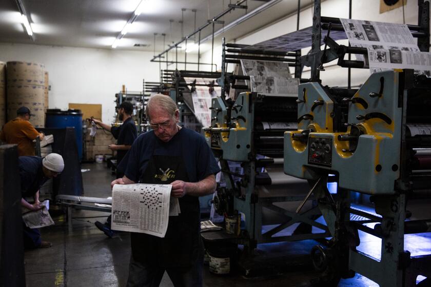 QUINCY, CALIF. - DECEMBER 13: Press operators check the freshly printed issue of The Mountain Messenger, the oldest weekly newspaper in Sierra County, at the pressroom of Feather Publishing Co., on Thursday, Dec. 13, 2018 in Quincy, Calif. Feather Publishing Co., prints and publishes four weekly papers in Pulmas County in addition to printing The Mountain Messenger which serves Sierra County. (Kent Nishimura / Los Angeles Times)