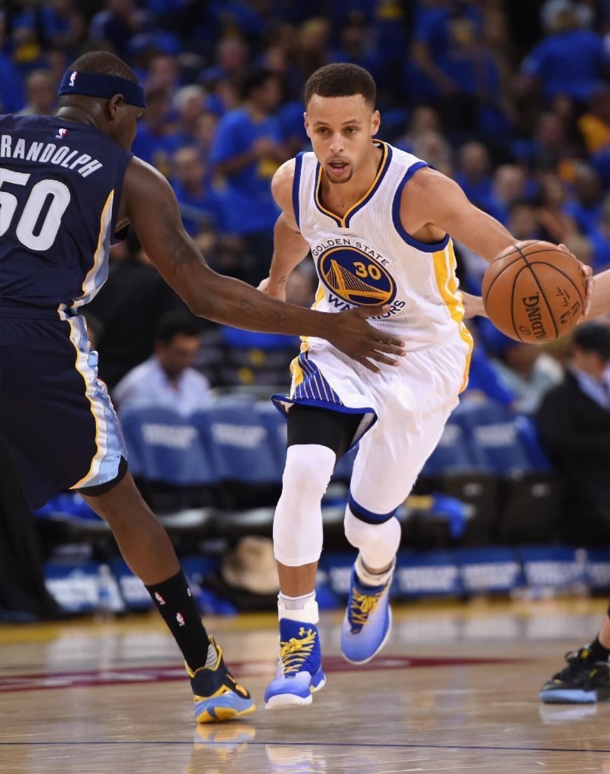Golden State Warriors player Stephen Curry, whose name adorns an Under Armour line of sports apparel, dribbles the ball against Zach Randolph of the Memphis Grizzlies at Oracle Arena on April 13 in Oakland.
