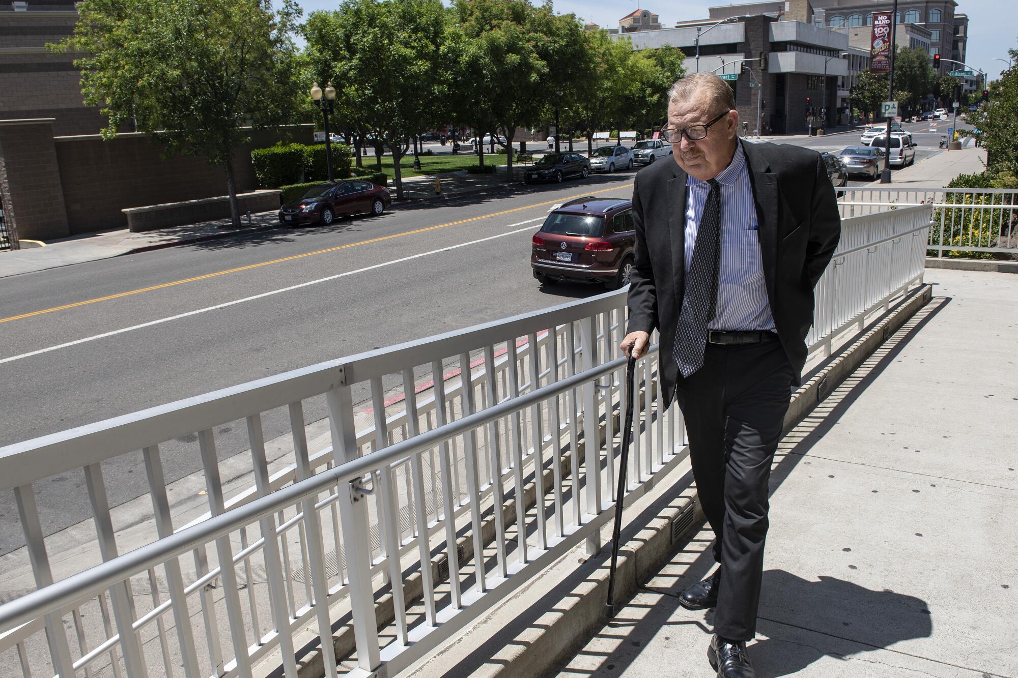 Modesto attorney Frank Carson walks with a cane on a ramp to court.