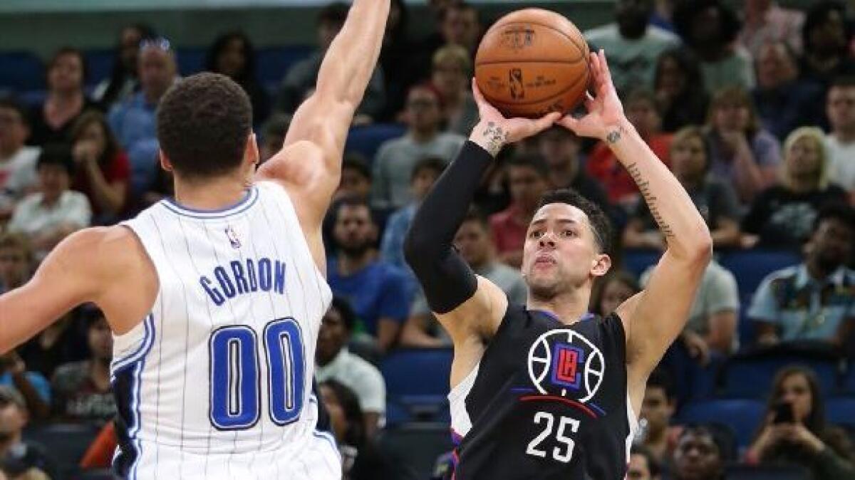Clippers guard Austin Rivers shoots a three-pointer over the outstretched hand of Magic forward Aaron Gordon during Wednesday's game.
