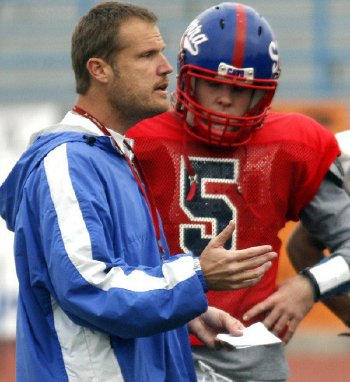 Gardena Serra Coach Scott Altenberg talks to quarterback Conner Preston duirng a practice.