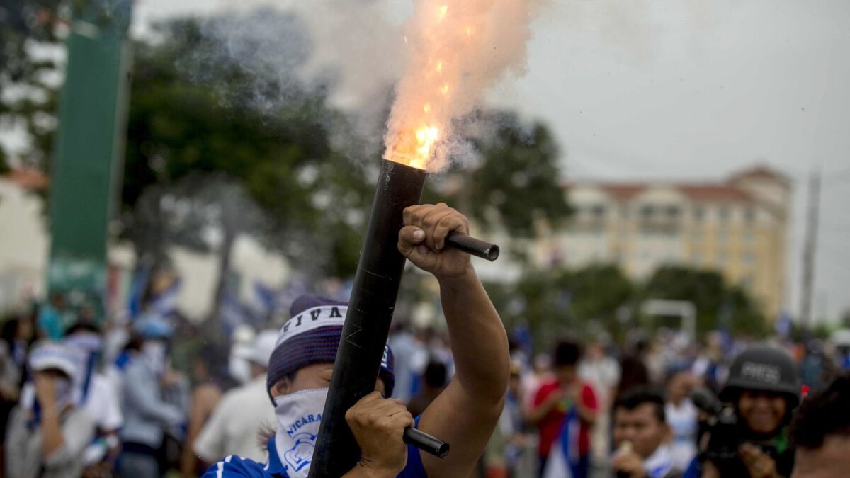 A young man fires a makeshift mortar during a march calling for President Daniel Ortega to be ousted in Managua, Nicaragua, on July 23, 2018.