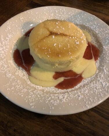 Crustless ricotta cheesecake on a plate decorated with swirls of strawberry jam 