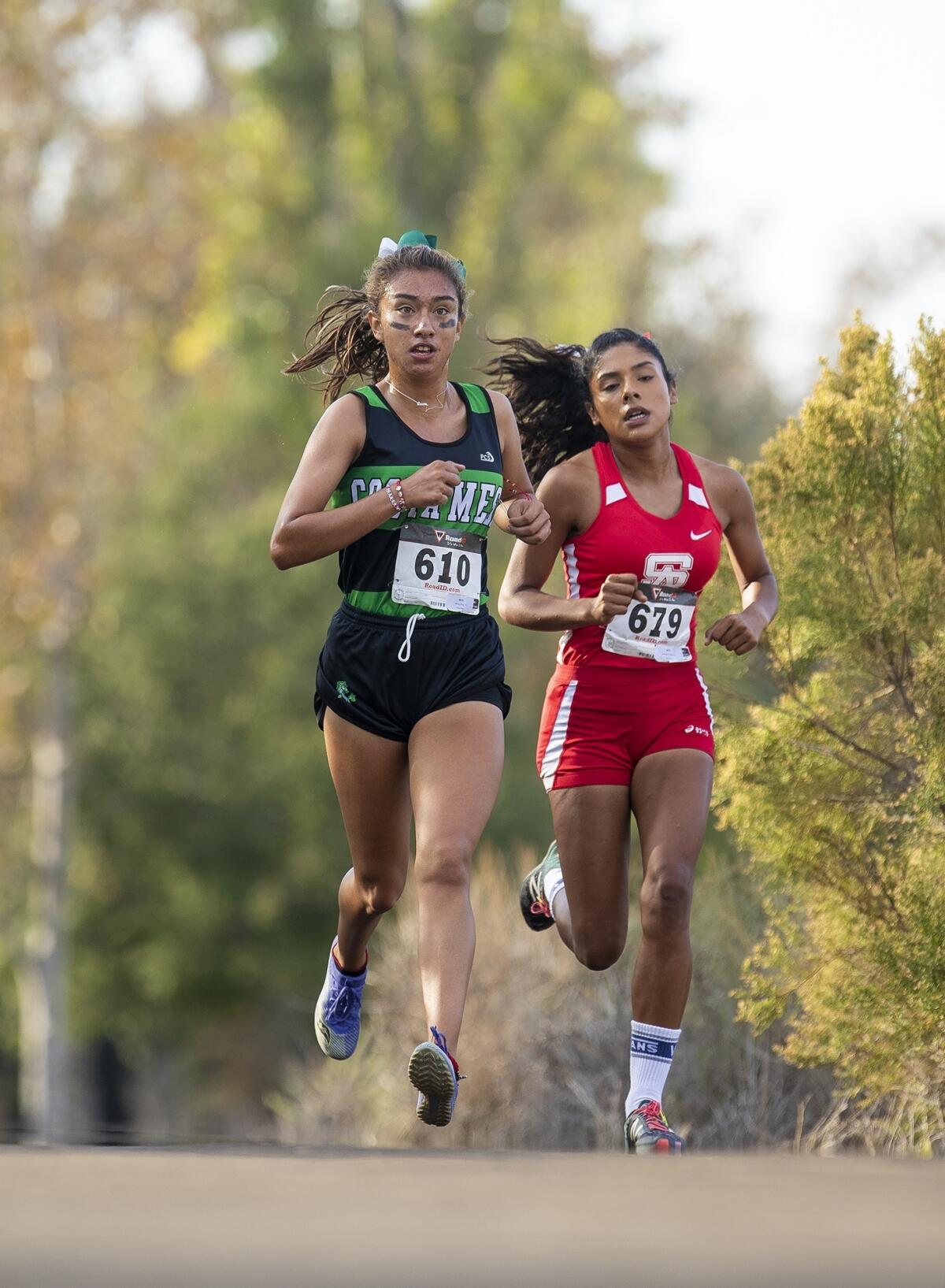 Costa Mesa's Diane Molina, left, and Santa Ana's Maria Hernandez battle it out in the second lap of the Orange Coast League finals at Irvine Regional Park in Orange on Oct. 29, 2018.