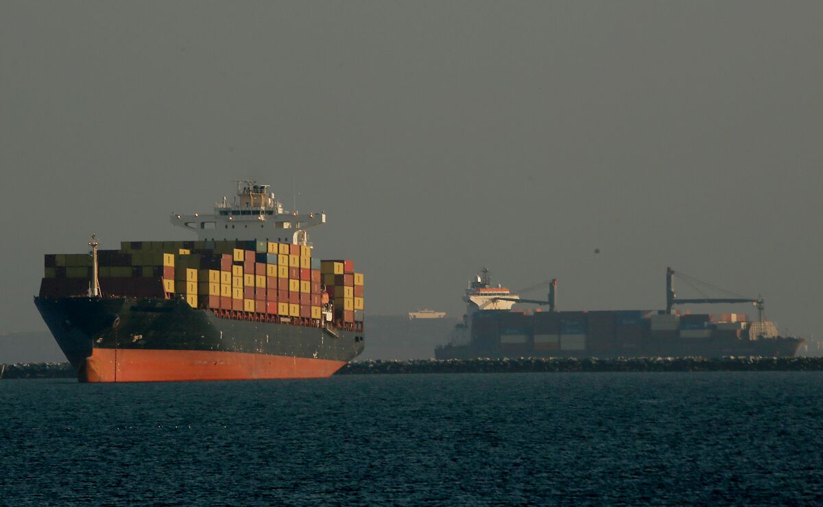 Container ships wait offshore.