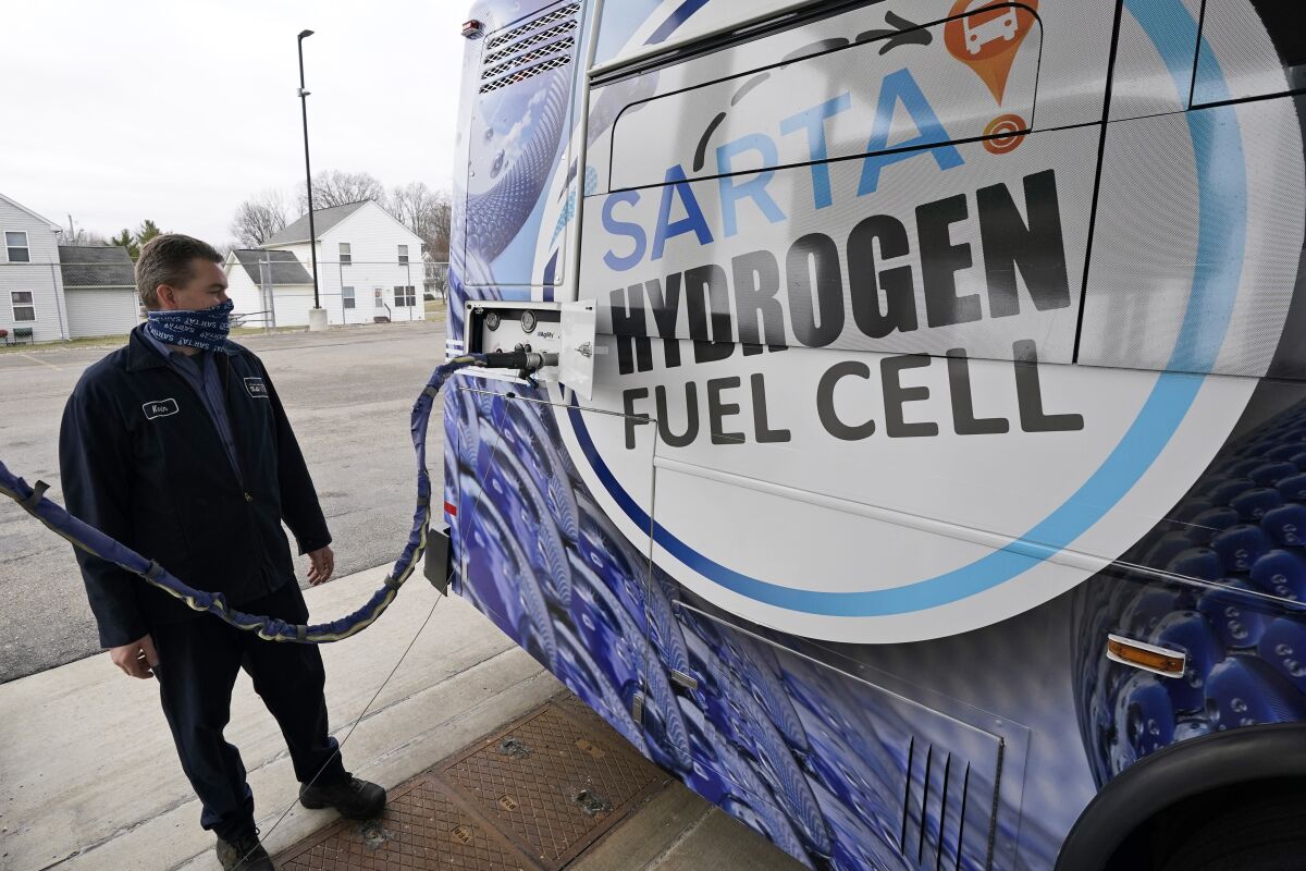 A maintenance technician refuels a hydrogen fuel cell bus on March 16, 2021, in Canton, Ohio. 
