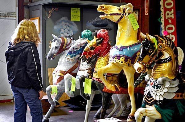A customer looks at carousel horses for sale at Hurlbut Amusement Co. in Buena Park.