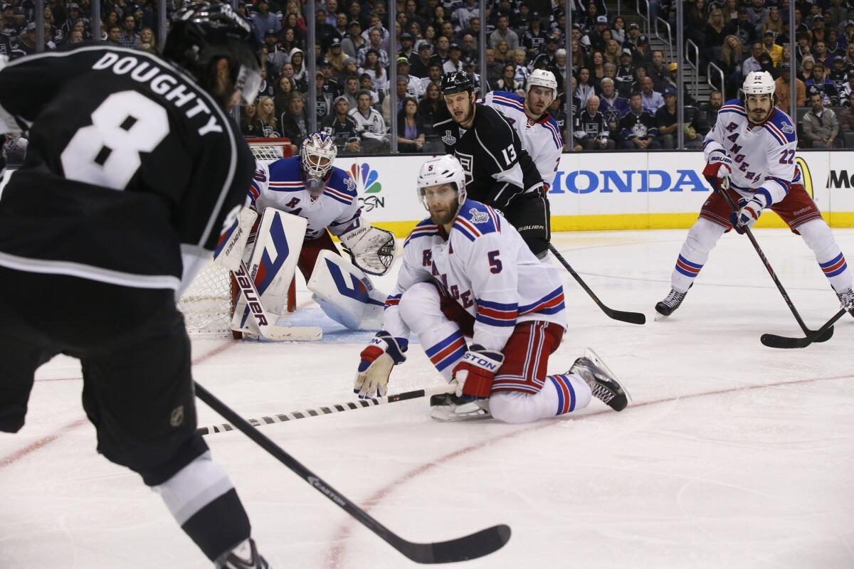Kings defenseman Drew Doughty, firing a shot toward Rangers defenseman Dan Girardi and goaltender Henrik Lundqvist in the second overtime of Game 2, is part of an offensive flurry upon which the team has relied in the playoffs.
