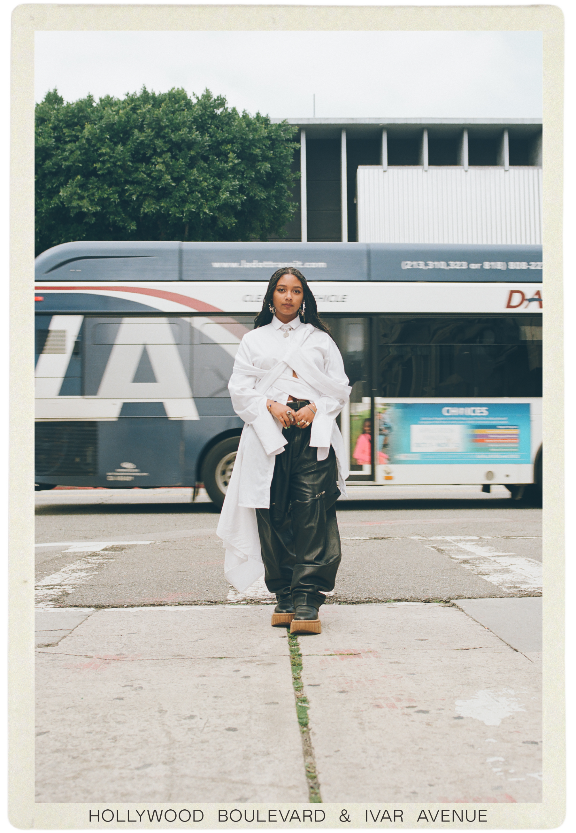 Safia Elhillo walks toward us, a bus passing behind her 