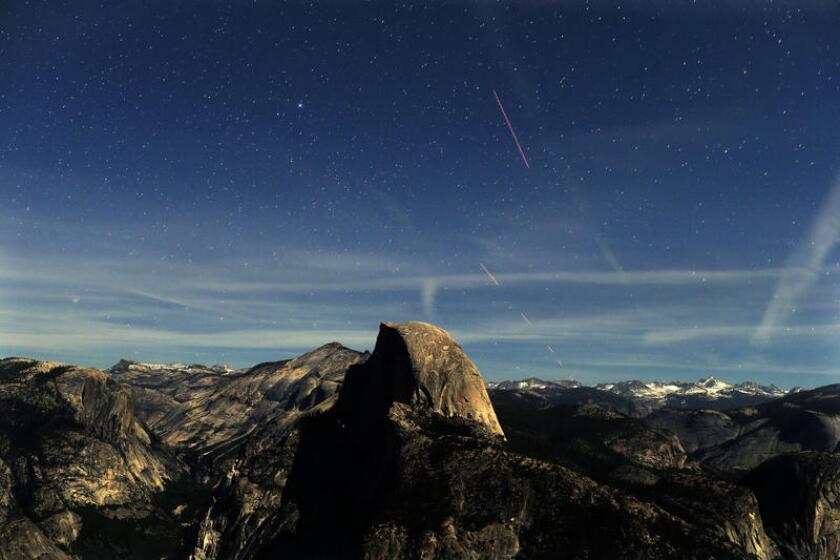 A long-exposure view of Half Dome from Glacier Point as stars appear.