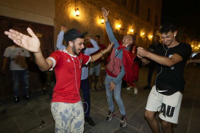 Moroccan soccer fans dance at the Souq Waqif during the FIFA World Cup, in Doha, Qatar on Sunday Dec. 4, 2022. (AP Photo/Ashley Landis)
