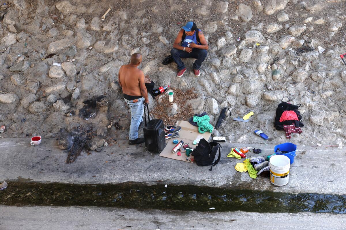 On Aug. 16, a pair of homeless men rested along the Pacoima Wash below State Route II8 in Pacoima.  