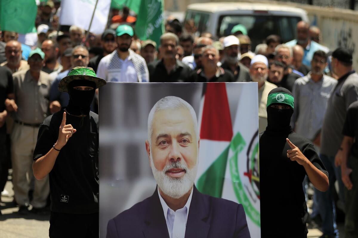 Miembros de Hamás sostienen una imagen del jefe político del grupo palestino, Ismail Haniyeh