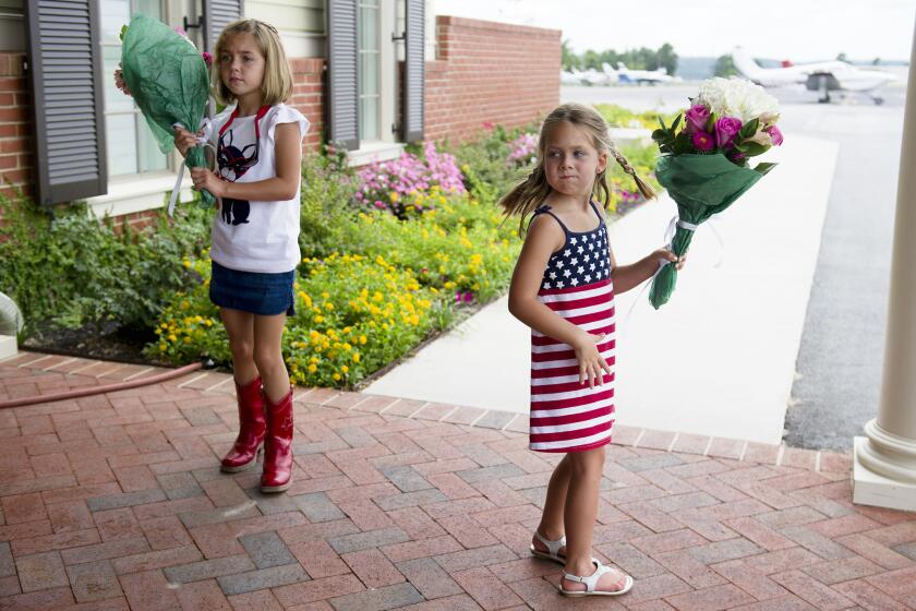 Kenzie Horton, 7, left, and her 5-year-old sister, Kardyn Horton, with with flowers for Republican U.S. Senate candidate David Perdue's plane to land in Augusta, Ga., on Monday during his final push across the state for votes in Tuesday's GOP primary runoff against Rep. Jack Kingston.