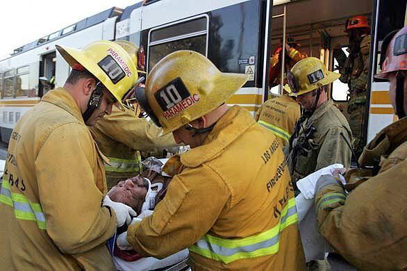 Los Angeles Fire Department paramedics tend to an injured passenger of a Metro Blue Line train after it collided with a bus in downtown Los Angeles. Fifteen people on the train, bound for Long Beach, suffered minor injuries. There were no passengers on the bus.