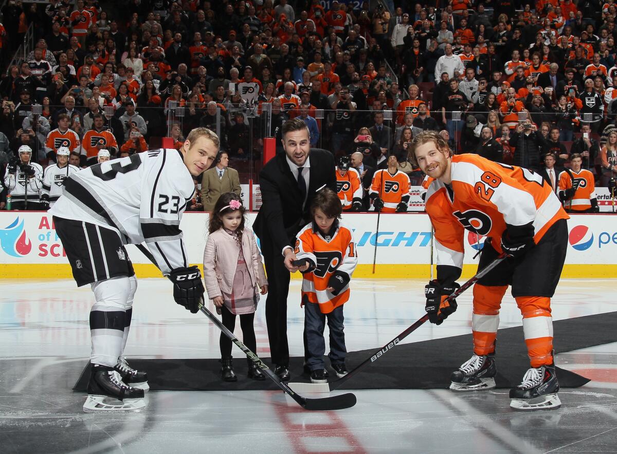 Former player Simon Gagne drops the puck between Kings' Dustin Brown and Philadelphia's Claude Giroux on Tuesday night.