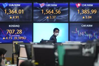 A currency trader walks by the screens showing the foreign exchange rates at a foreign exchange dealing room in Seoul, South Korea, Wednesday, Dec. 21, 2022. Shares were mixed in Asia on Wednesday after a modestly higher close on Wall Street as concerns over pressures on global growth tempered gains in the absence of major data releases. (AP Photo/Lee Jin-man)