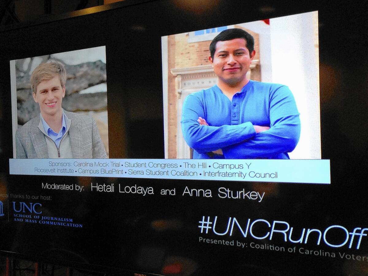 A display screen during an election debate at the University of North Carolina shows the runoff candidates for student body president, Andrew Powell, left, and Emilio Vicente.