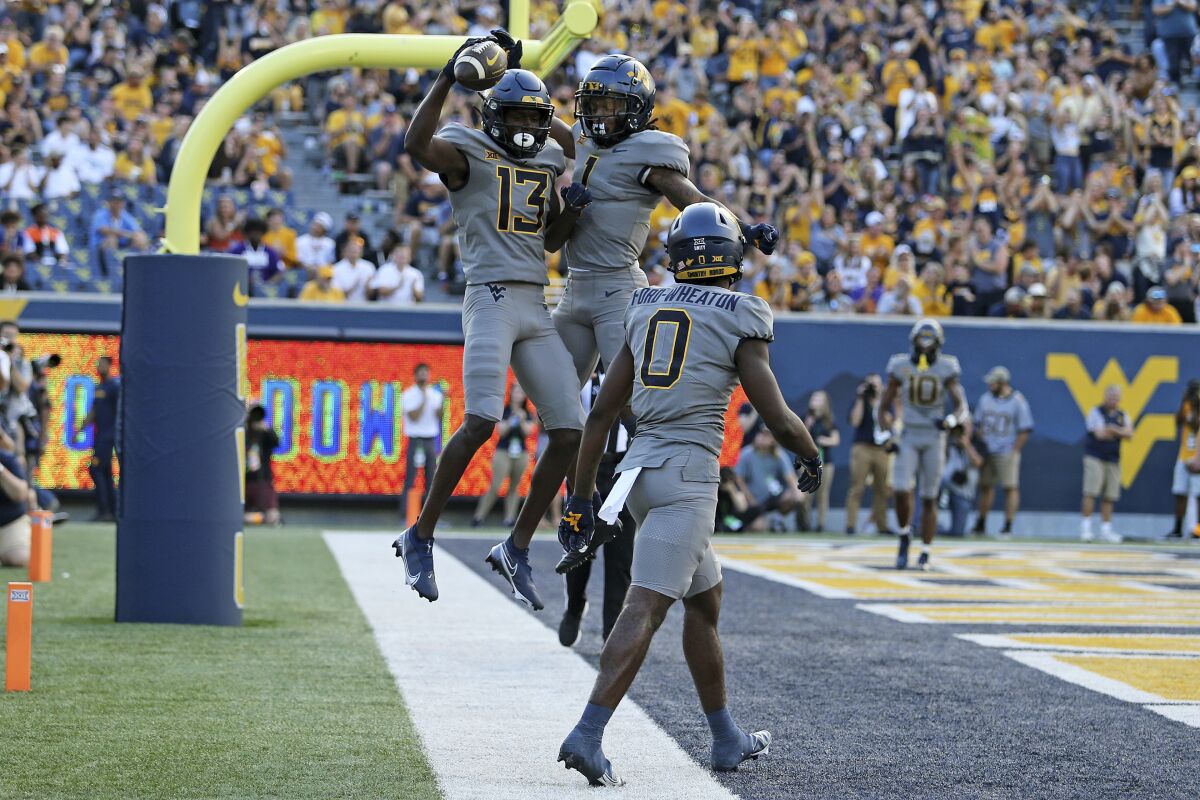 West Virginia wide receivers Sam James (13) and Winston Wright Jr. (1) celebrate after a touchdown against Long Island during the first half of an NCAA college football game in Morgantown, W.Va., Saturday, Sept., 11, 2021. (AP Photo/Kathleen Batten)