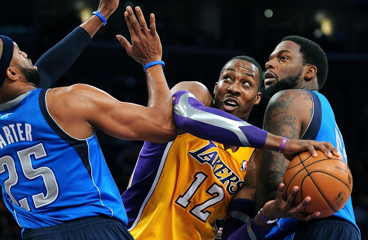 The Lakers' Dwight Howard tries to get around Maverick defenders Vince Carter and Eddy Curry.