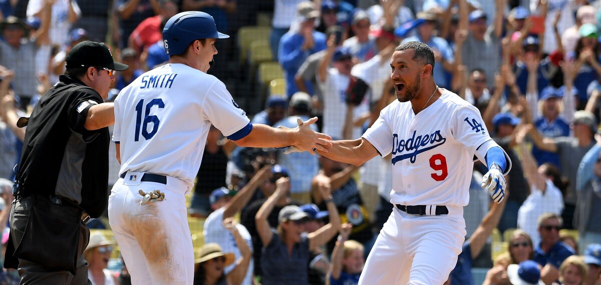 Will Smith congratulates Dodgers teammate Kristopher Negron after he scored the wining run on Aug. 7, 2019.