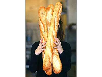 At Santa Monica's Le Pain du Jour, Karine Commereuc holds an armful of her husband's freshly baked baguettes.