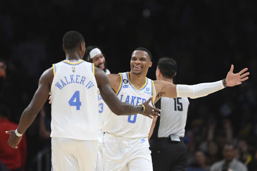 Los Angeles Lakers guards Russell Westbrook (0) and Lonnie Walker IV (4) celebrate in the closing minutes of the second half of an NBA basketball game against the Denver Nuggets Sunday, Oct. 30, 2022, in Los Angeles. The Lakers won 121-110. (AP Photo/Michael Owen Baker)