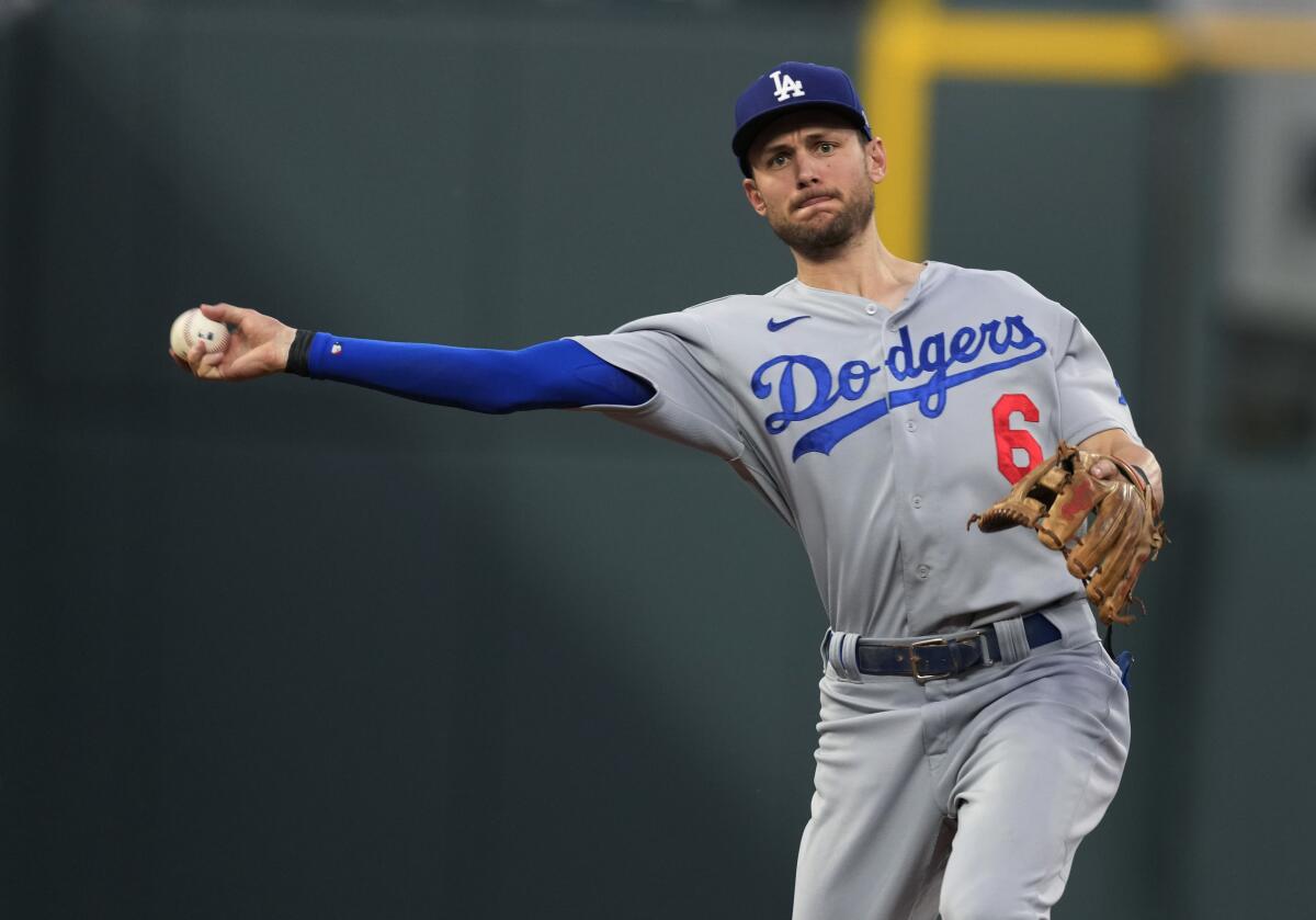 Los Angeles Dodgers shortstop Trea Turner thorws to first base to put out Colorado Rockies' Yonathan Daza.