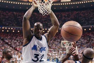 Orlando Magic center Shaquille O'Neal (32) hangs from the rim after a slam-dunk 