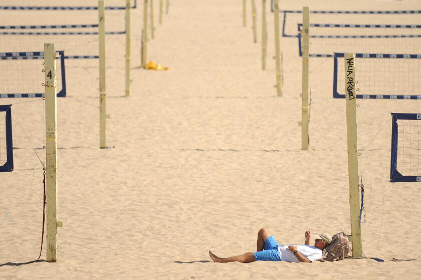Frank Kaiser of Lawndale relaxes among the beach volleyball courts in Manhattan Beach on Aug. 28.