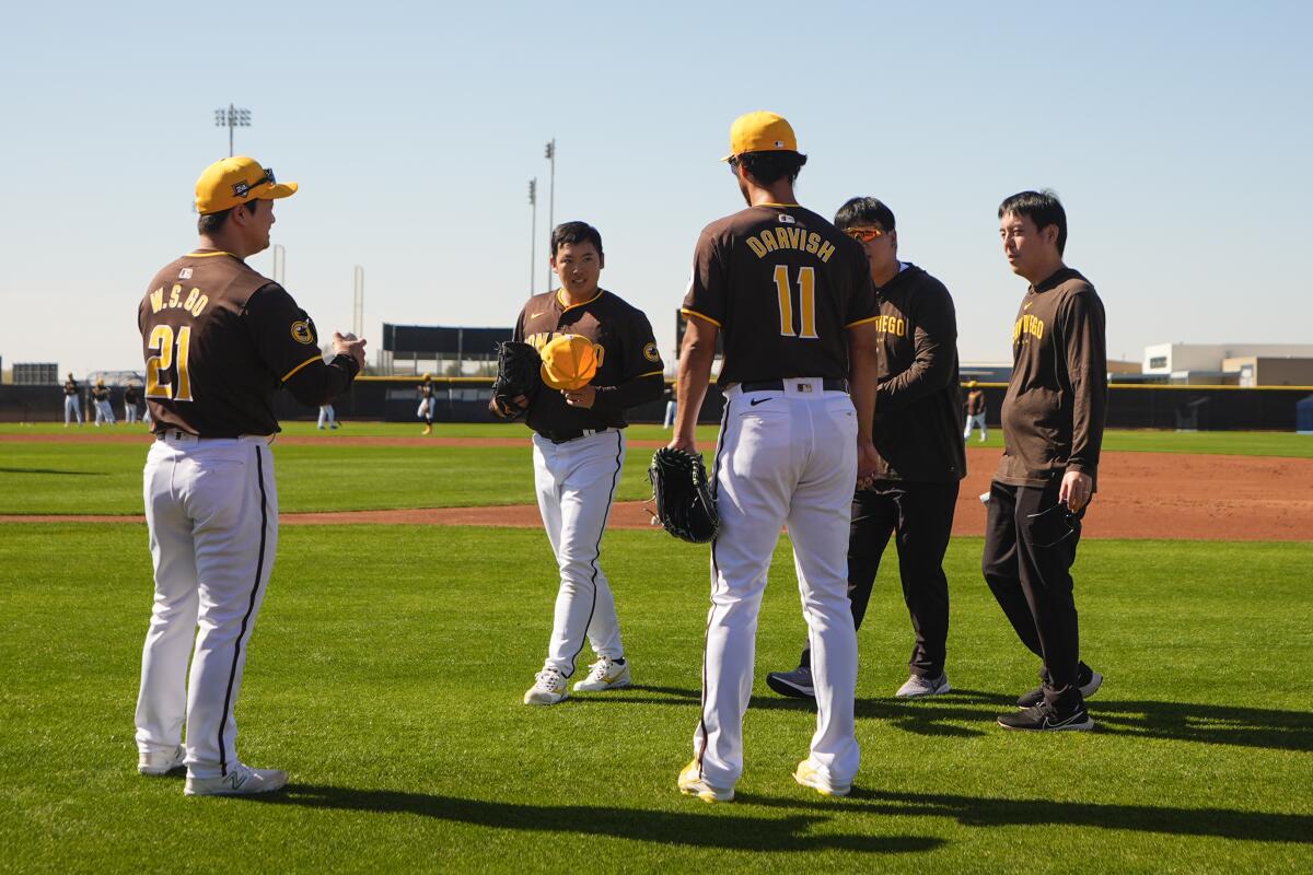 Padres relief pitcher Woo-Suk Go talks with Yuki Matsui, center, and Yu Darvish during spring training last month.